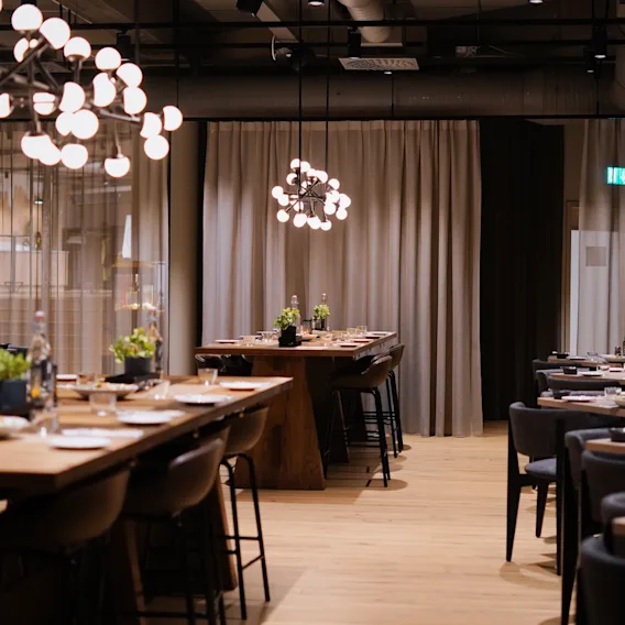 Quality Hotel Arlanda XPO:s eleganta matsal, förberedd för gäster med vackert dukade bord och varm belysning.