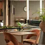A cozy hotel lounge area with comfortable seating, lush green plants, and a warm ambiance at Home Hotel Grand Bodø.