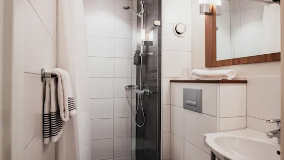 A bright and inviting bathroom with a refreshing shower area and vanity. Perfect for unwinding. add Home Hotel Kung Oscar
