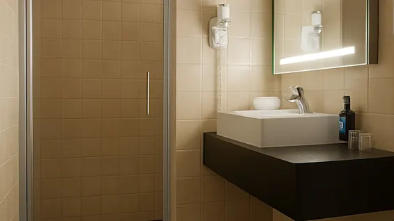 Et moderne baderom med rent design. Et stort speil med belysning henger over en elegant vask. En glassdør til dusjen og nøytrale fliser gir en minimalistisk følelse.