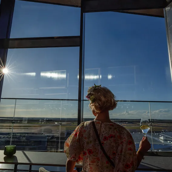 Nauttimassa virkistävästä juomasta upealla, aurinkoisella näkymällä lentokentälle Clarion Hotel Helsinki Airportin baarista.