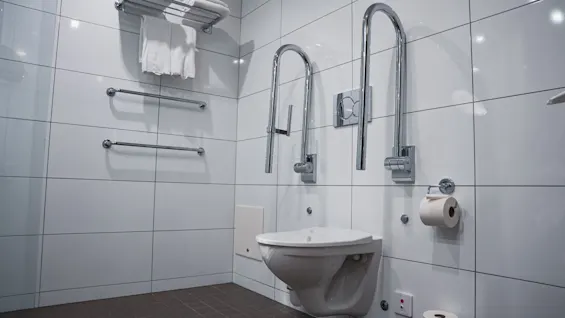 Esteetön kylpyhuone Quality Hotel Viewssa, jossa on seinäkiinnitteinen wc, tukikahvat ja puhtaat pyyhkeet.