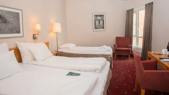 Standard trippleroom at Home Hotel Bryggeparken, made bed and chair