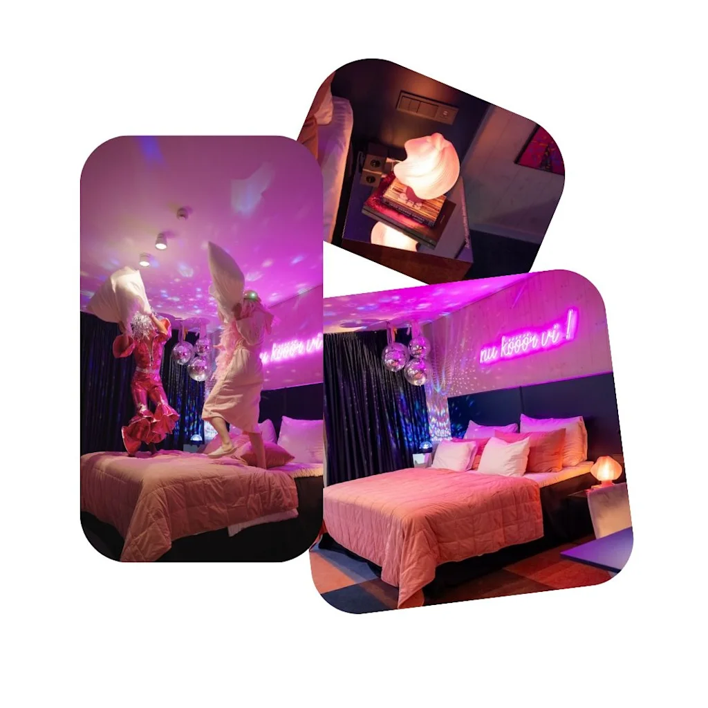 Ett livligt hotellrum med rosa belysning, discokulor och en 'nu kor vi' neonskylt, med lekfull aktivitet på sängen.