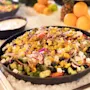 En levende og frisk salat, med en blanding af farverige grøntsager og ost, smukt præsenteret på en seng af is.
