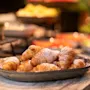Lautanen kultaisia croissanteja tomusokerilla, valmiina nautittavaksi buffetissa.