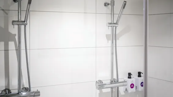 Et moderne dusjområde med to dusjhoder og dispensere, i en Juniorsuite på Quality Airport Hotel Værnes.