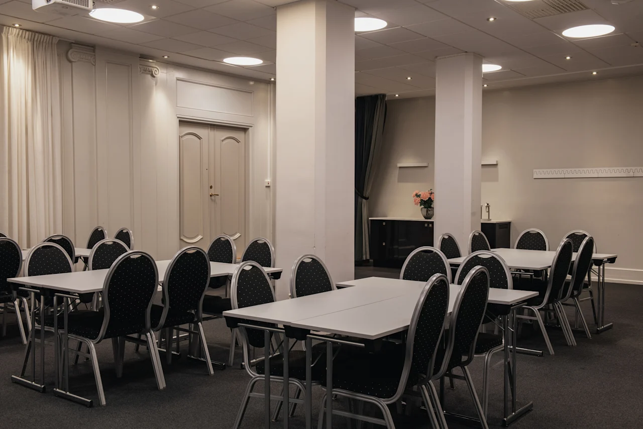 Konferensrum med flera bord och stolar arrangerade för ett möte eller evenemang på Home Hotel Grand, Helsingborg.