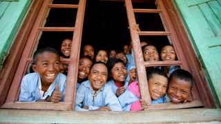 Glada skolbarn i ett fönster