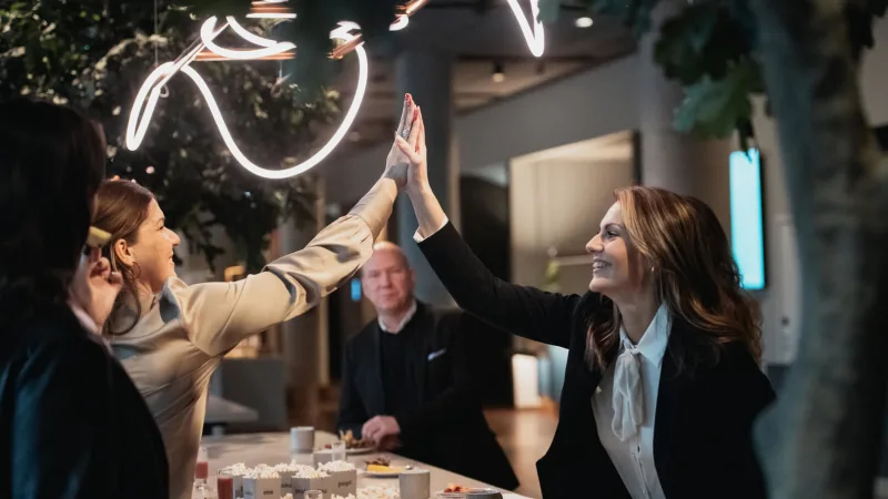 Two people doing high five at a conference.