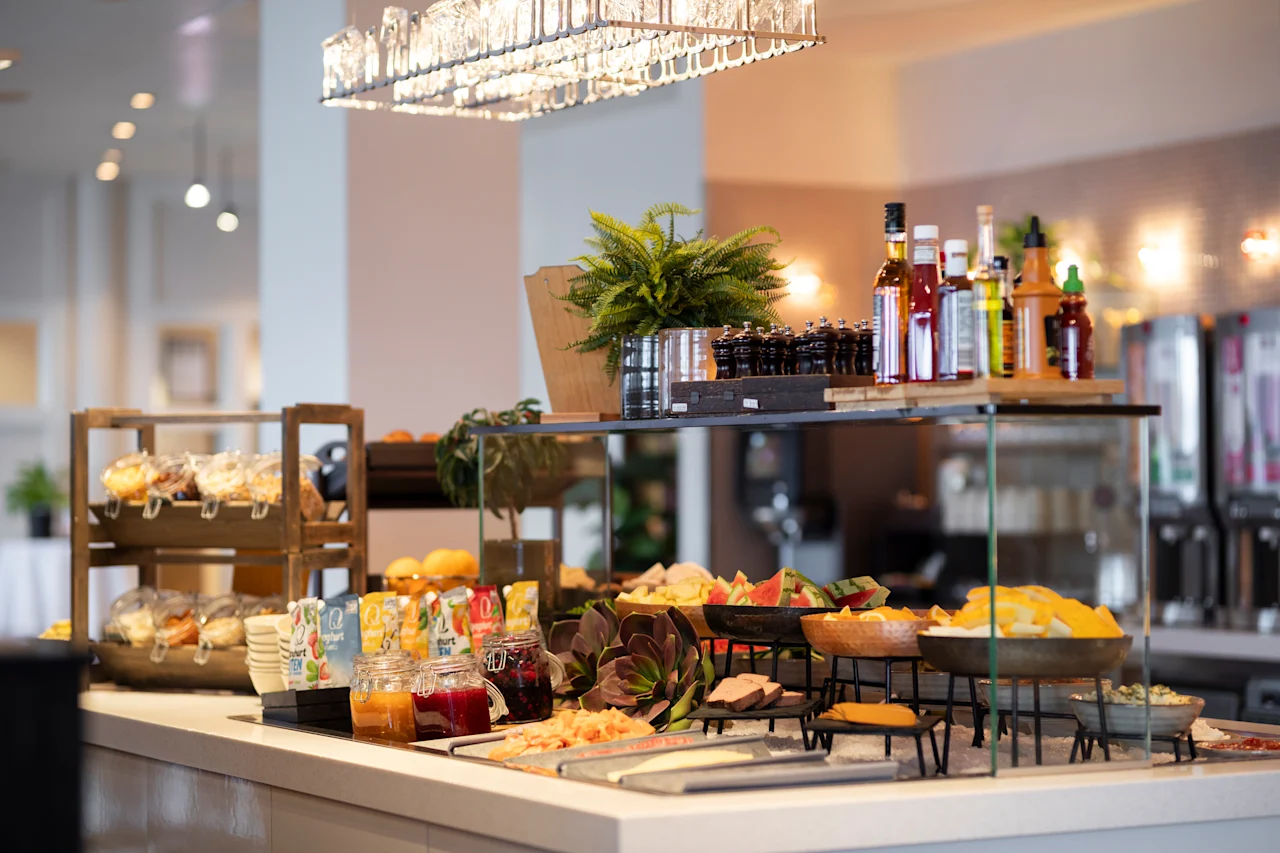 Eloisa buffetti, jossa on tuoreita hedelmiä, leivonnaisia ja erilaisia mausteita, valmiina vieraille nautittavaksi herkullisesta ateriasta.