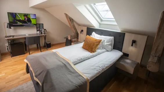 Home Hotel Bryggeparken Compact single room, made bed and tv on wall.