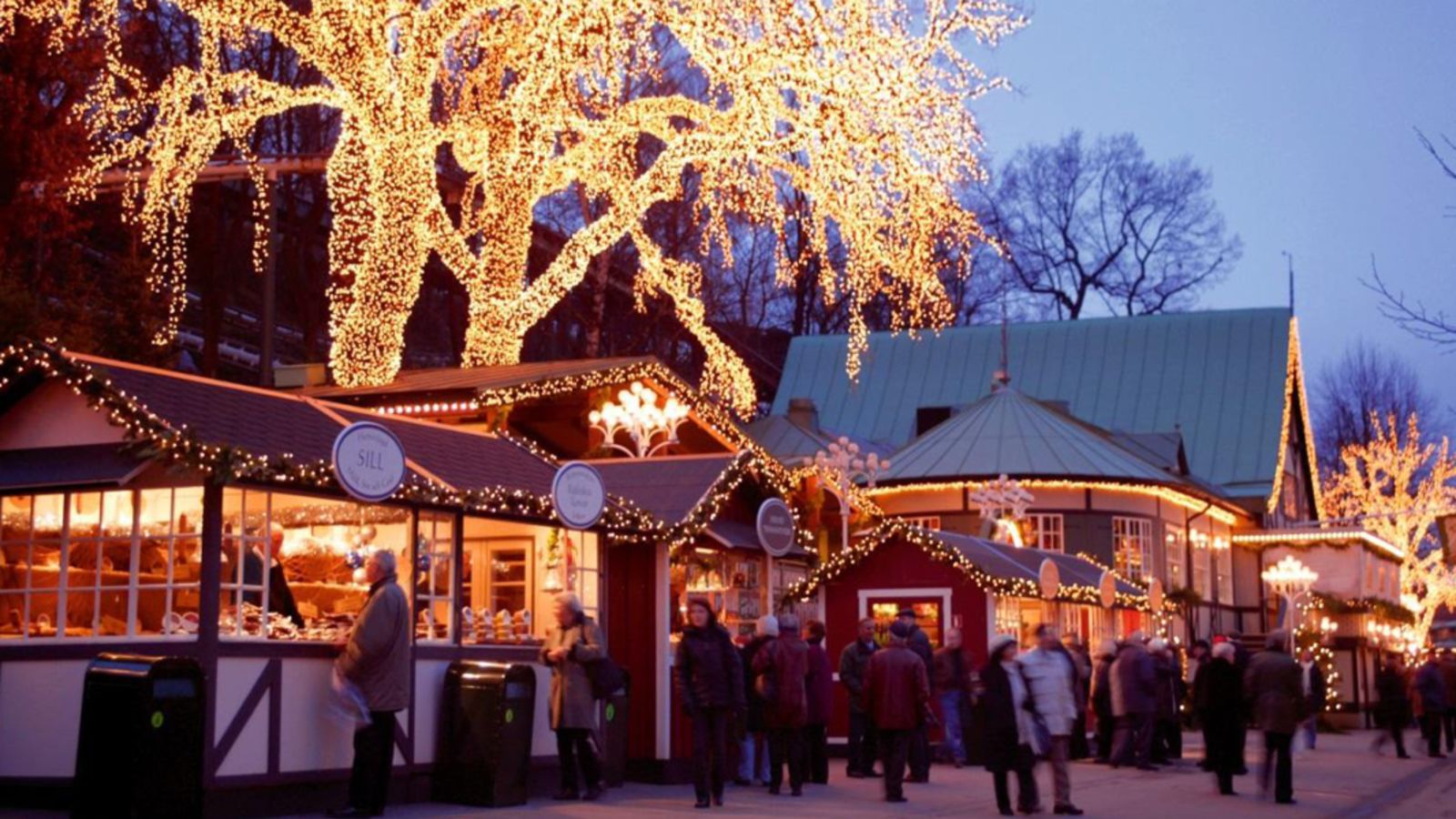 Julbelysning i träd lyser upp en traditionell julmarknad. 