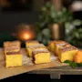 Lækre firkantede kager drysset med flormelis, pyntet med en appelsinskalrose og mynte, placeret i en varm og indbydende atmosfære.