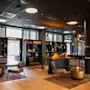 En stilig hotellounge med moderne peis, bokhyller, komfortable stoler og store vinduer.