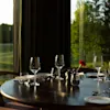  wine glass on set table in restaurant on table with golf course in background