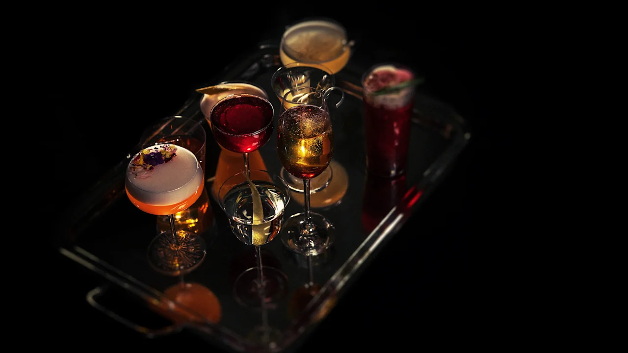 A tray of beautifully crafted cocktails with various colors and garnishes, ready to be served at Hotel Kämp – Kämp Bar.