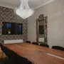 Tyylikäs kokoushuone, jossa on pitkä puupöytä, mustat tuolit, televisio, kattokruunu ja koristeellinen peili. Ovessa lukee "Stora Villa".