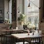Et koselig bar- eller restaurantinteriør med trebord, stoler og mange planter ved et stort vindu. Et skilt leser BAR Kallens Vi.