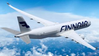 Et Finnair-fly flyr over blå himmel. 