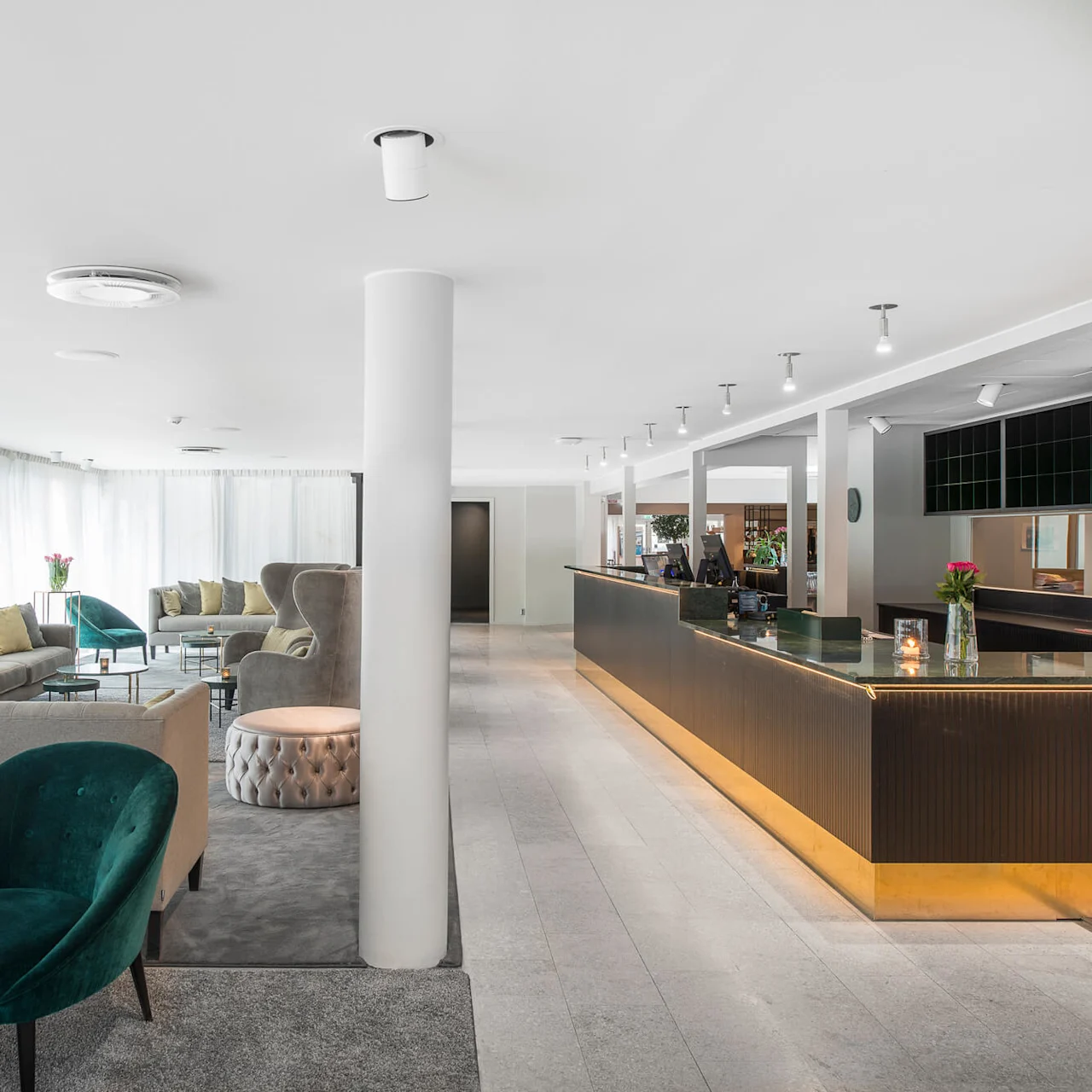 Lyxig hotellobby med turkos och grå sittgrupp, elegant svart receptionsdisk och mjuk belysning. Elegant inredning med färska blommor på bord och en rymlig, ljus atmosfär med skira gardiner.