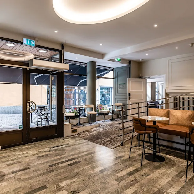 Et innbydende lobbyområde på Comfort Hotel Linkoping City med ulike sitteplasser og utsikt mot gaten utenfor.