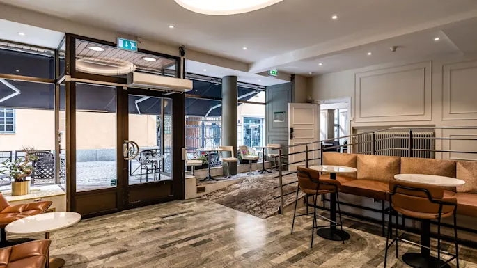 Et innbydende lobbyområde på Comfort Hotel Linkoping City med ulike sitteplasser og utsikt mot gaten utenfor.