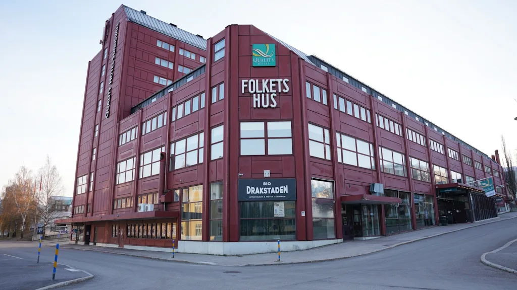 Quality Hotel Sundsvall, suuri punainen rakennus, jossa on Folkets Hus ja Bio Drakstaden -kyltit, kuvattuna kadunkulmasta.