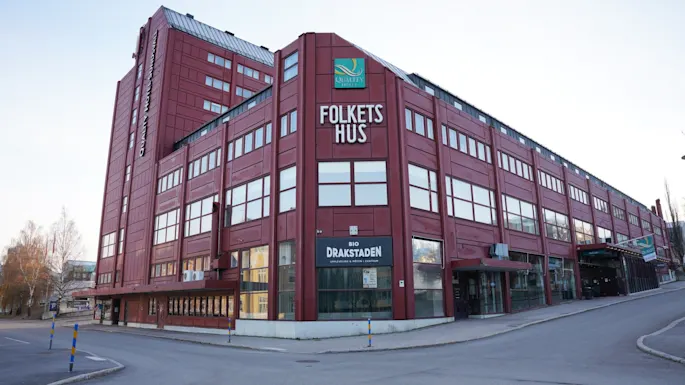 Quality Hotel Sundsvall, en stor rød bygning med skilt for Folkets Hus og Bio Drakstaden, sett fra et gatehjørne.