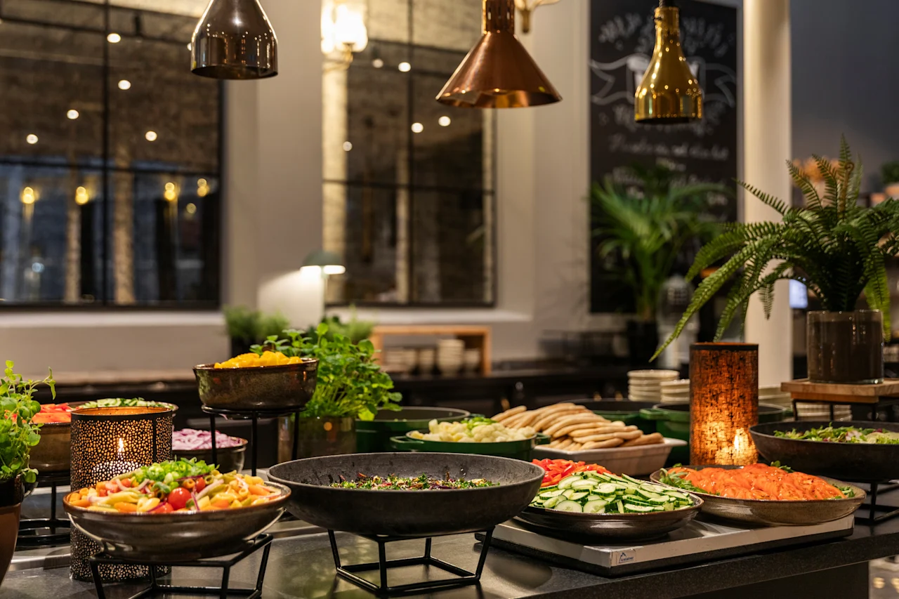 A vibrant buffet spread at Home Hotel Grand Bodø, featuring an array of fresh salads and warm dishes in an inviting setting.