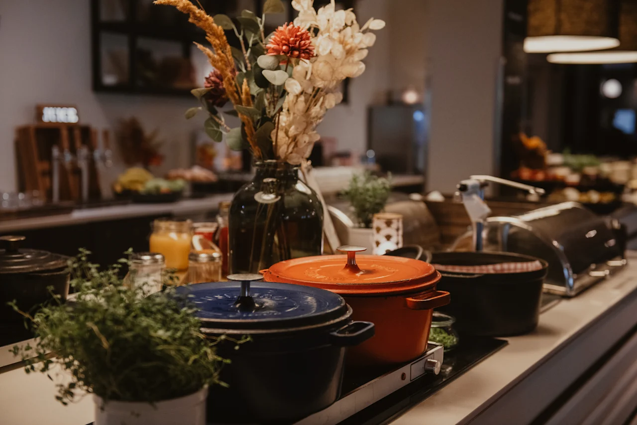 En varm og indbydende buffetopstilling med varm mad i farverige gryder, friske dekorationer og en juicestation.