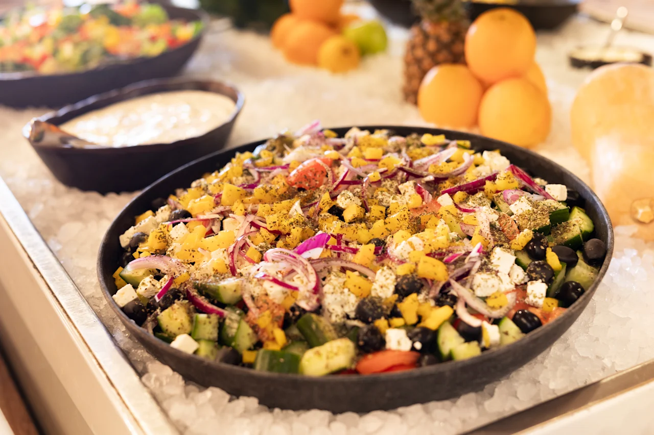 En levende og frisk salat, med en blanding af farverige grøntsager og ost, smukt præsenteret på en seng af is.