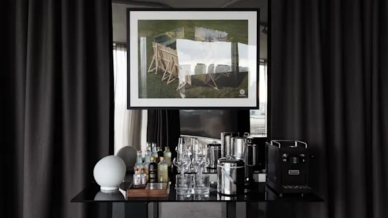 Mini bar in a Stratum Suite at Clarion Hotel Sign in Stockholm with various drinks, glassware, and a coffee machine.