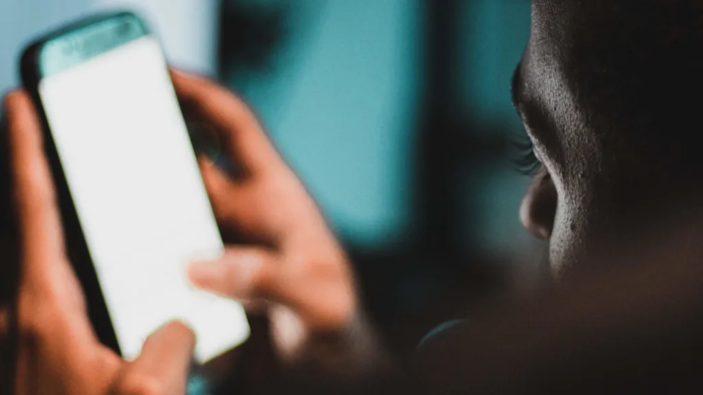 Man looking at his smartphone. Photo: Mehdi Lamaaffar, Unsplash.