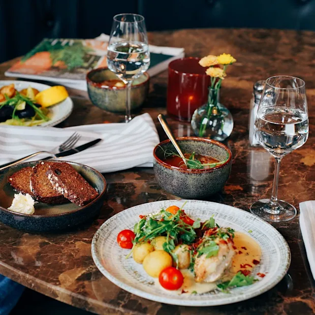 En variation av rätter på ett marmorbord tyder på en måltid på en restaurang.