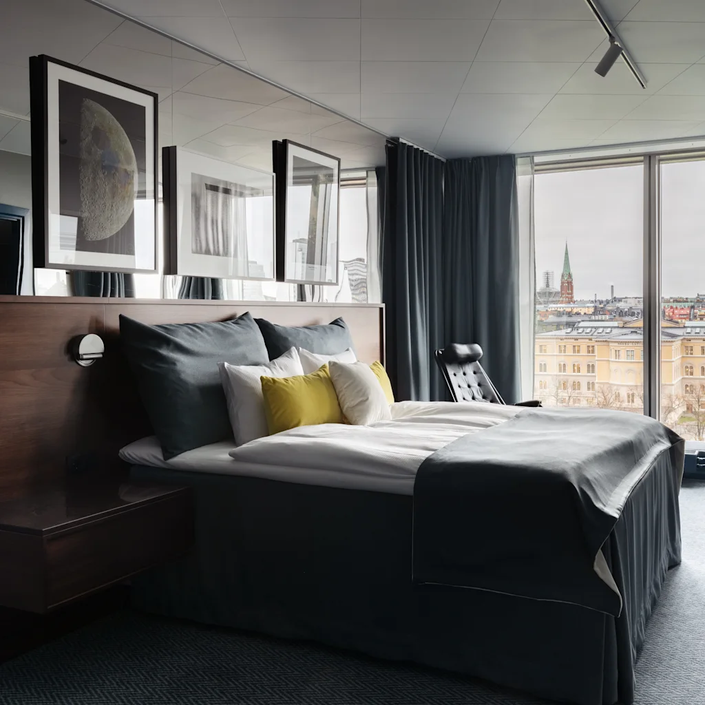 A modern hotel room with a comfortable bed and a city view. Stratum Suite by Bernadotte and Kylberg at Clarion Hotel Sign.