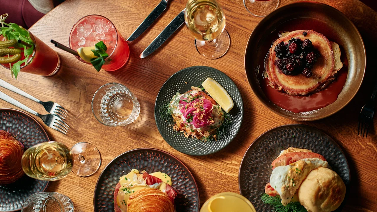 En deilig brunsjopplevelse på Clarion Hotel Post med pannekaker, croissanter og cocktails på et trebord.