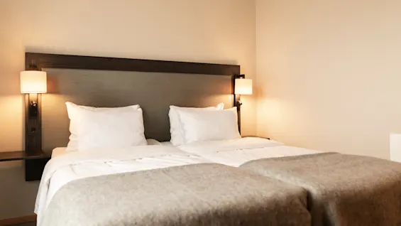 Et varmt og indbydende hotelværelse med to komfortable senge, perfekt til et afslappende ophold.