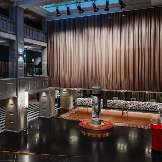 Clarion Hotel Post – Gemensamt område – En storslagen hotellobby i flera plan med stor ridå, reception och central skulptur.