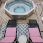 An inviting outdoor hot tub area with two lounge chairs on a wooden deck, perfect for relaxation.