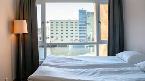 Compact Doubleroom with a view of buildings and water.