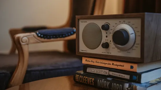 En radio med HOME HOTEL vilar på böcker: Glada halsningar fran Missangertrask, Domino, Mork Jord i en mysig miljö.