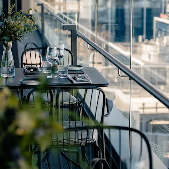 Kutsuva ulkoruokailupöytä Restaurant NÒRissa Clarion Hotel Helsinki Airportissa, kaupunkinäkymällä.
