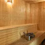 Viihtyisä puusauna pehmeällä valaistuksella, penkeillä ja tarvikkeilla virkistävää höyryhetkeä varten. 🧖‍♀️