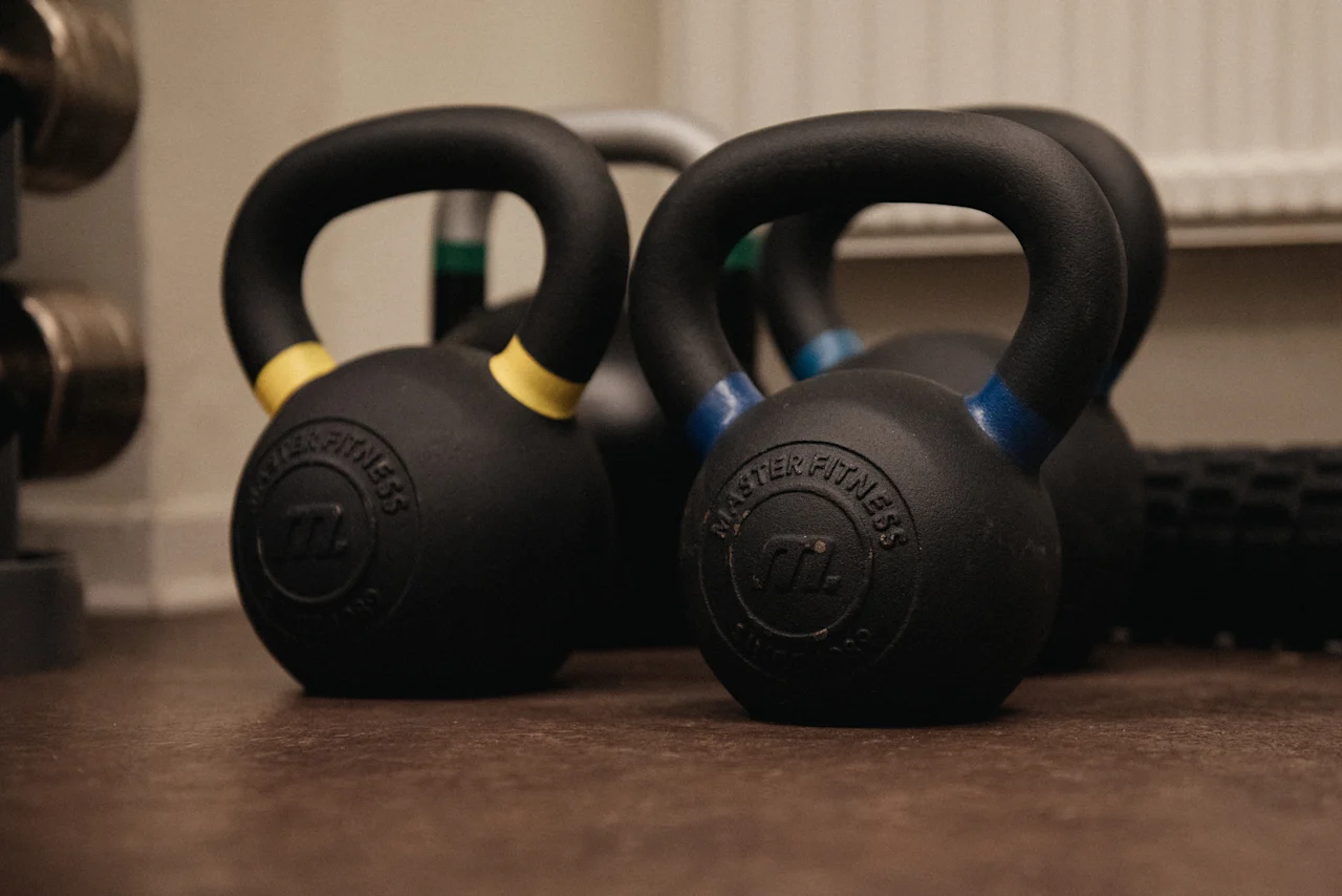Kettlebells and other fitness equipment on the floor, ready for a workout at Home Hotel Kung Oscar.