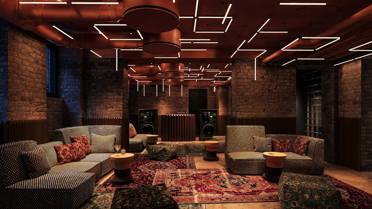A cozy, modern lounge with brick walls, comfortable sofas, oriental rugs, and unique geometric ceiling lights.