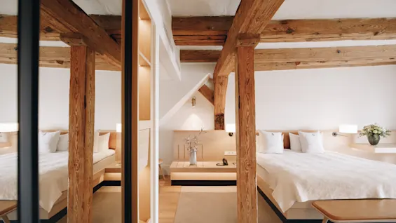 Mysigt hotellrum med rustika trabalkar och en stor dubbelsang