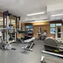 Et velutstyrt hotellgym med ulike treningsapparater, inkludert vekter, benker og kondisjonsutstyr, klart for en treningsøkt.