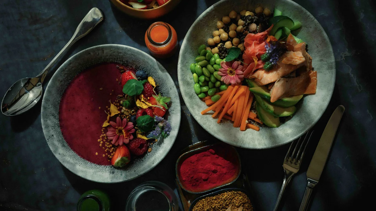 Two vibrant bowls of healthy food, one a berry smoothie bowl and the other a colorful poke bowl, arranged on a dark table.