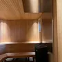 Et varmt, innbydende badstuerom med trebenker og vegger, med en varmeovn og myk belysning. Home Hotel Bilan Wellness.